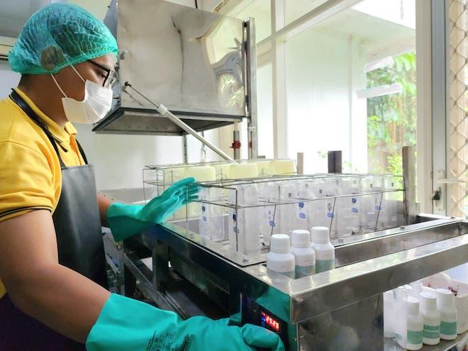 A worker uses a cleaning and sanitizing machine.