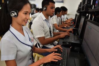 Students of the Laguna State Polytechnic University, San Pablo campus intently viewing their work on a computer. 